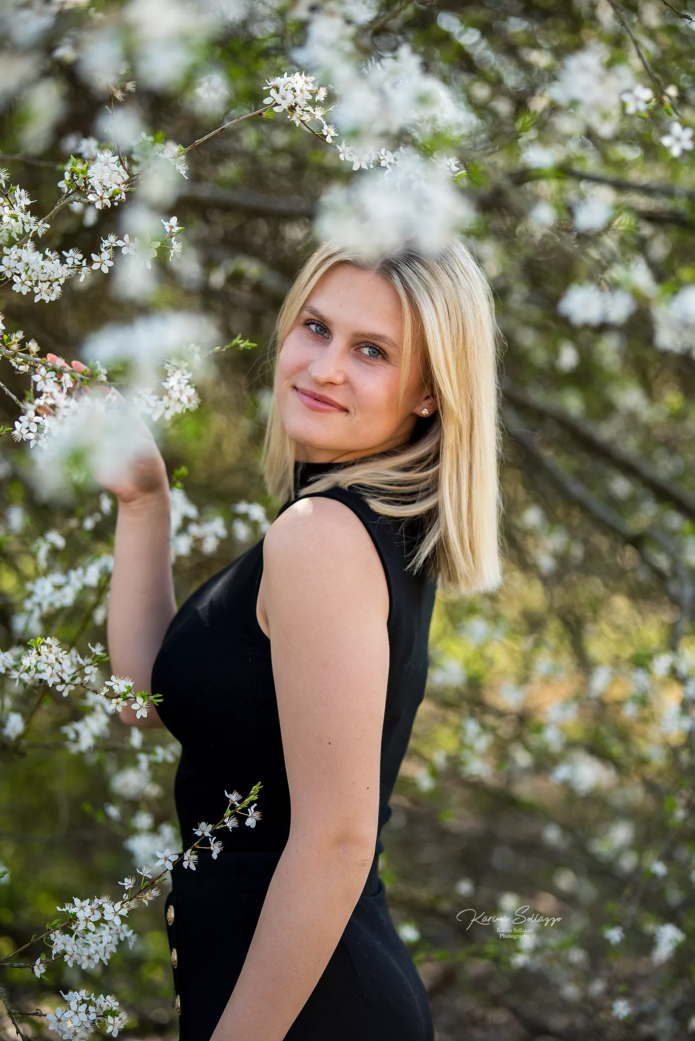 Portrait von blonder Frau vor Kirschblüten