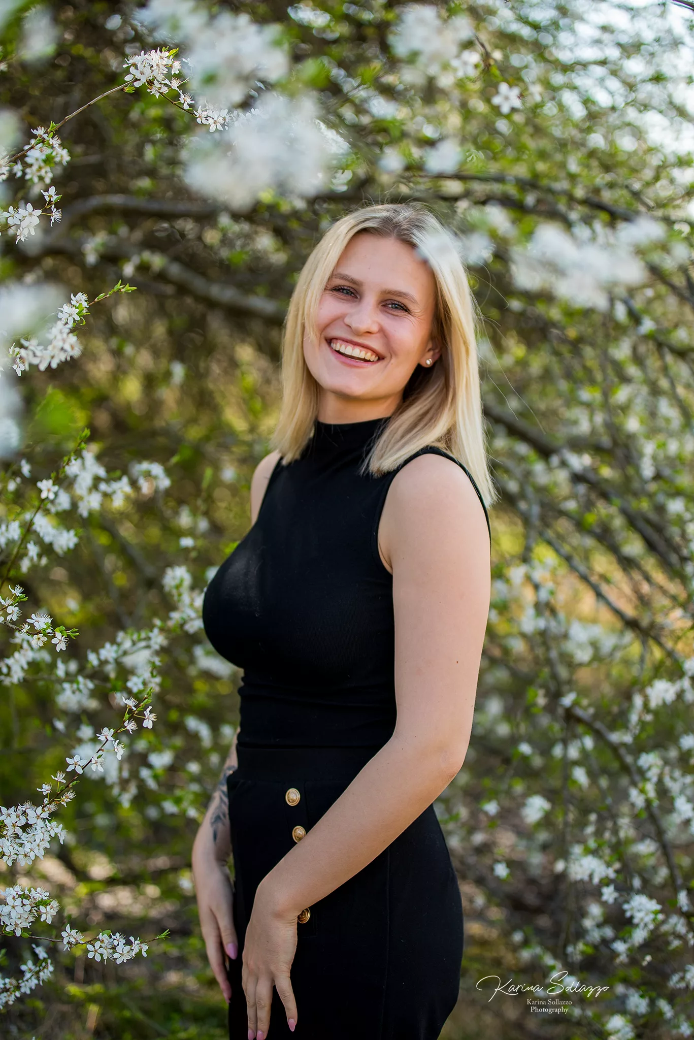 Portrait von blonder Frau vor Kirschblüten