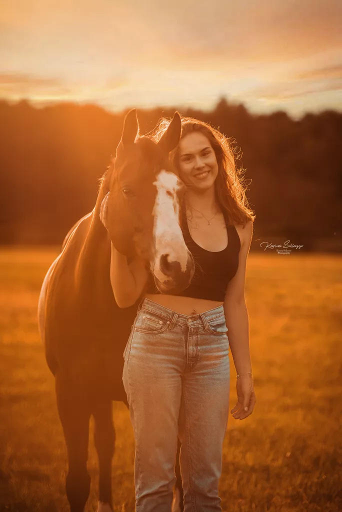 Pferd mit Besitzer im Sonnenuntergang