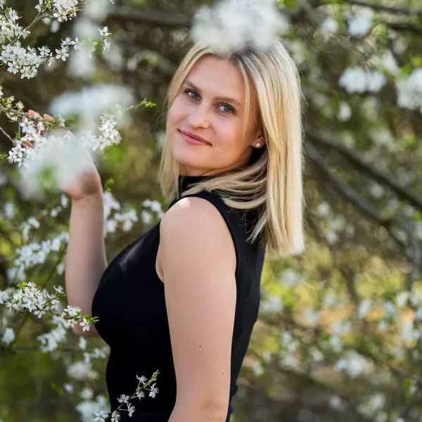 Portrait von blonder Frau vor Kirschblüten