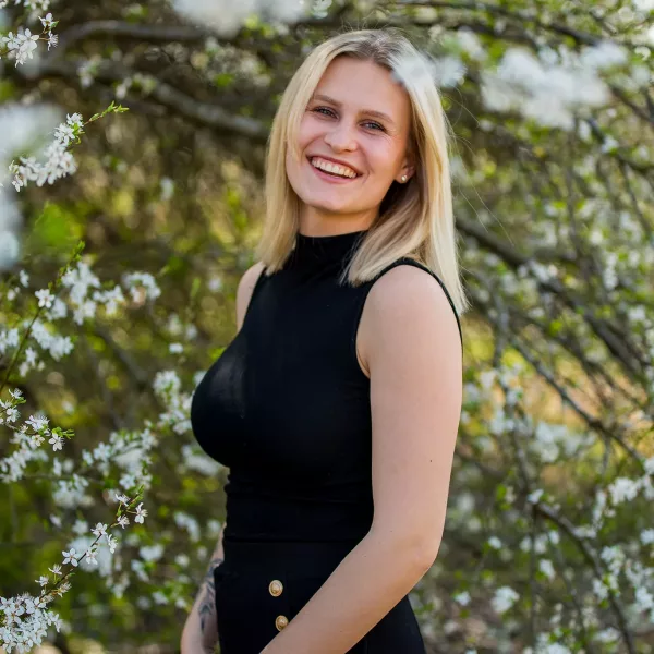 Portrait von blonder Frau vor Kirschblüten