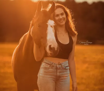 Pferd mit Besitzer im Sonnenuntergang