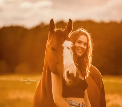 Pferd mit Besitzer im Sonnenuntergang