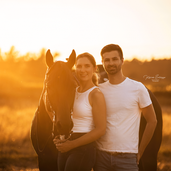 Paar mit Pferd im Sonnenuntergang