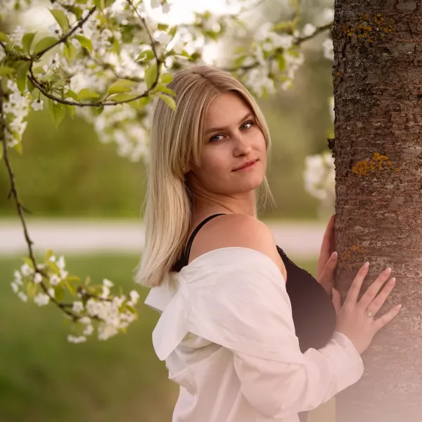 Blondes Mädchen unter Kirschblütenbaum